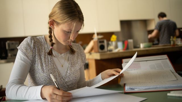 A young girl learning at home.