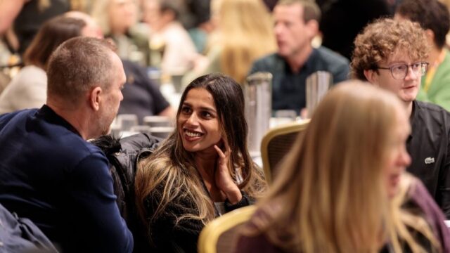 a woman in conversation with someone, smiling