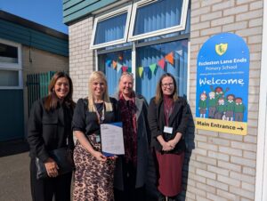 A teacher from Eccleston Lane Ends primary school stood with 3 people from Career Connect outside the school with a new careers accreditation certificate