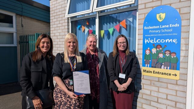 A teacher from Eccleston Lane Ends primary school stood with 3 people from Career Connect outside the school with a new careers accreditation certificate