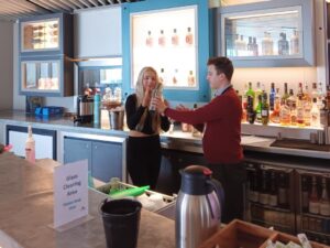 A young woman taking part in a make your own mocktail session at the bar of the Lowry.