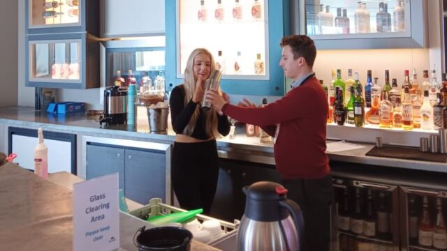 A young woman taking part in a make your own mocktail session at the bar of the Lowry.