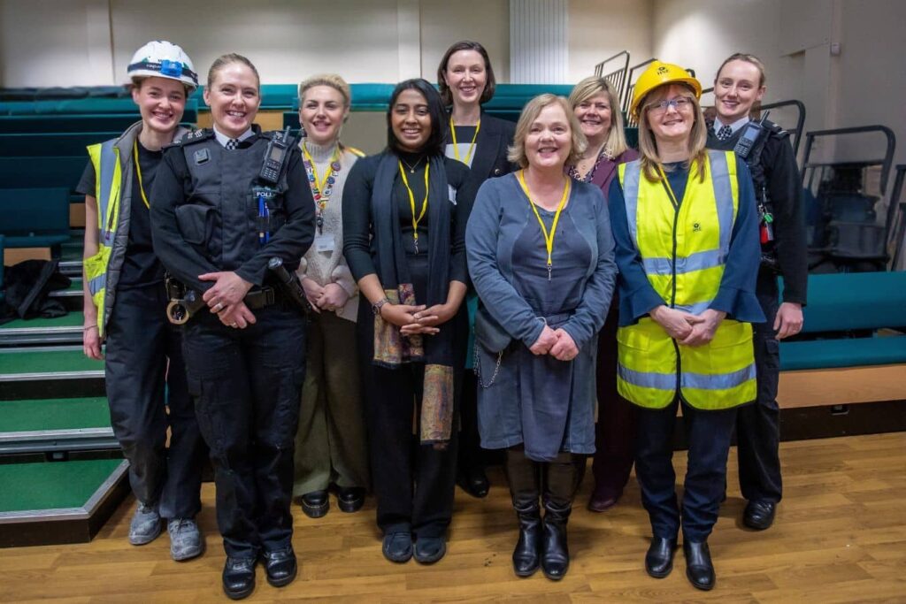 A group of professional women stood together in various different uniforms