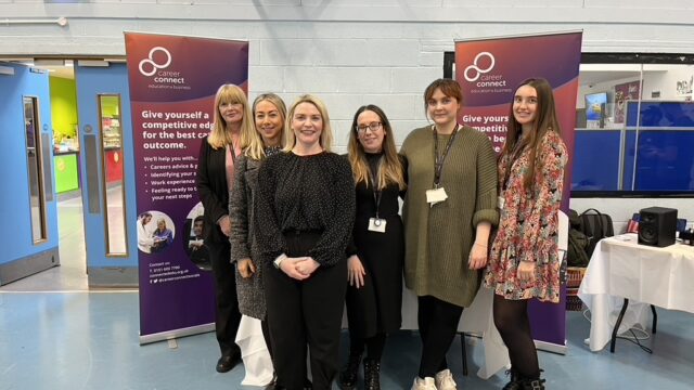 A group of Career Connect staff standing in a group at a careers fair. They are all smiling at the camera.