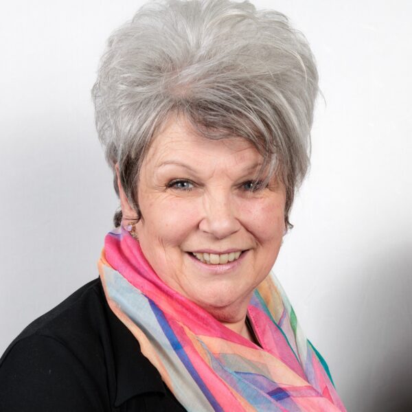 Head and shoulders photo of Carmel Skidmore. Carmel is wearing a bright scarf and smiling.