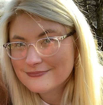 Head and shoulders photo of Katie Haynes. Katie is smiling and wears glasses.
