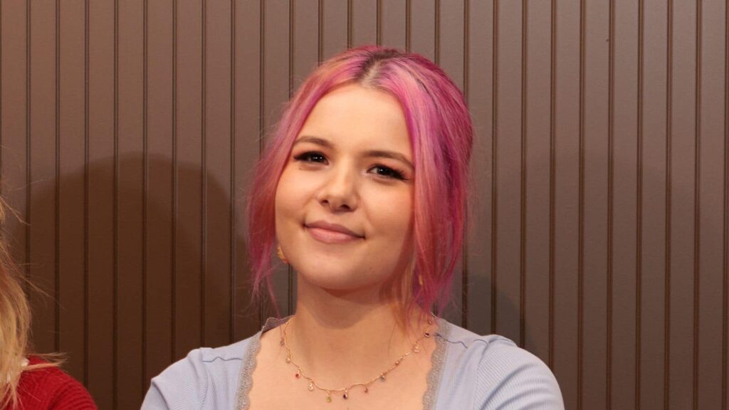 A headshot of Klaudia, an apprentice at Career Connect. She is smiling and has pink hair