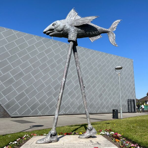 A statue of a fish with legs