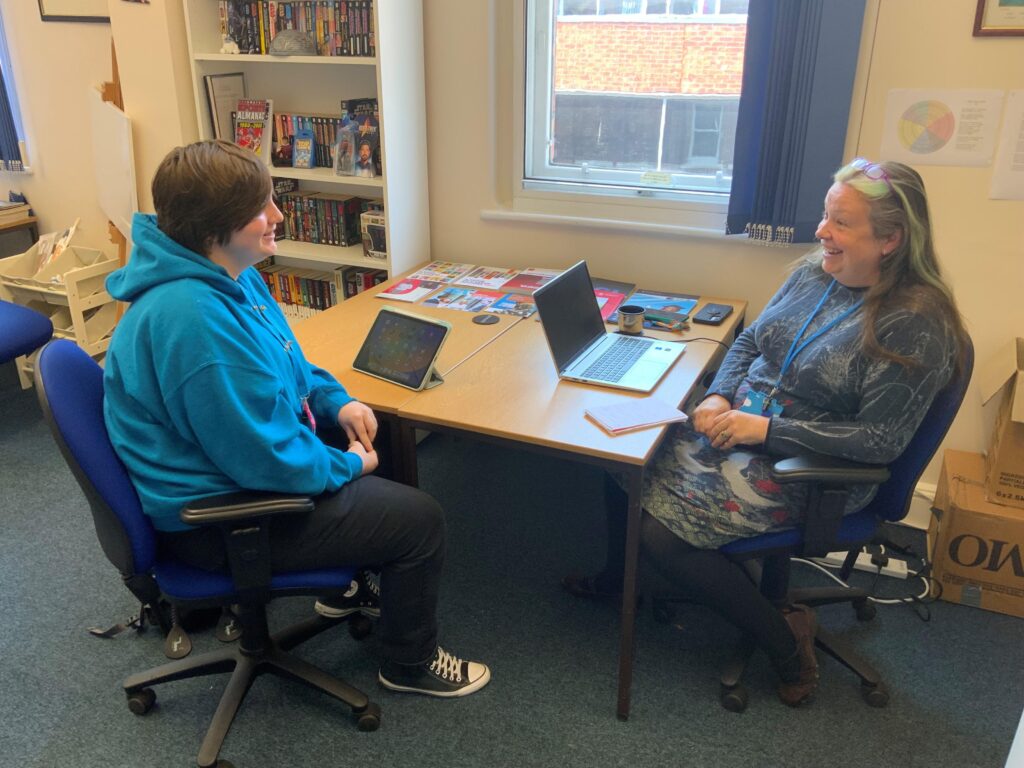 A young person in a careers interview with a Career Connect adviser. They are laughing.