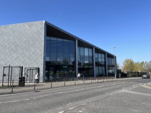 a photo of a grey building by a road on a sunny day