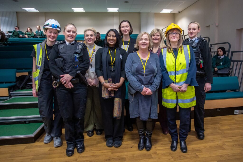 A group of professional women stood together in various different uniforms