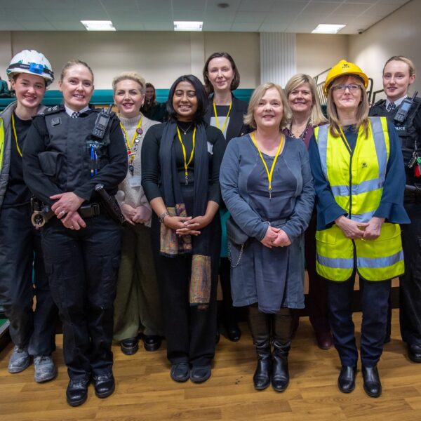 A group of professional women stood together in various different uniforms