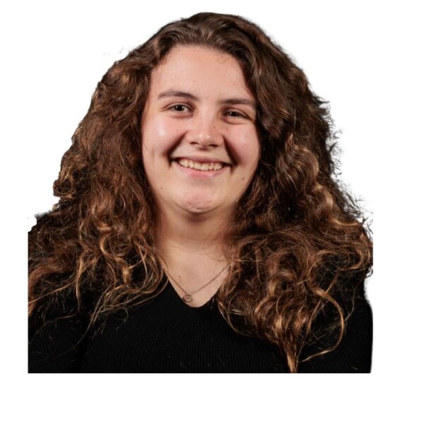 Head and shoulders shot of Rachel. She has curly brown hair and a black top. She is smiling.
