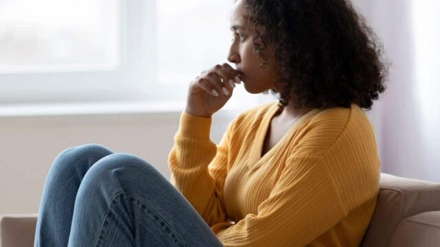 a woman sat down on a sofa looking anxious