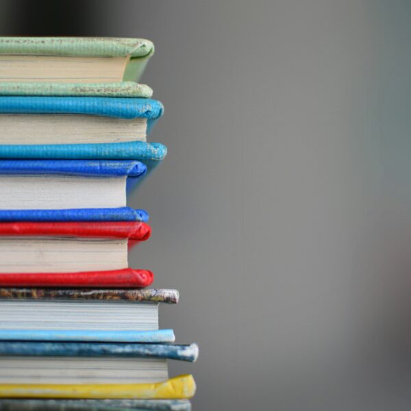 A photo of a stack of books in different colours.