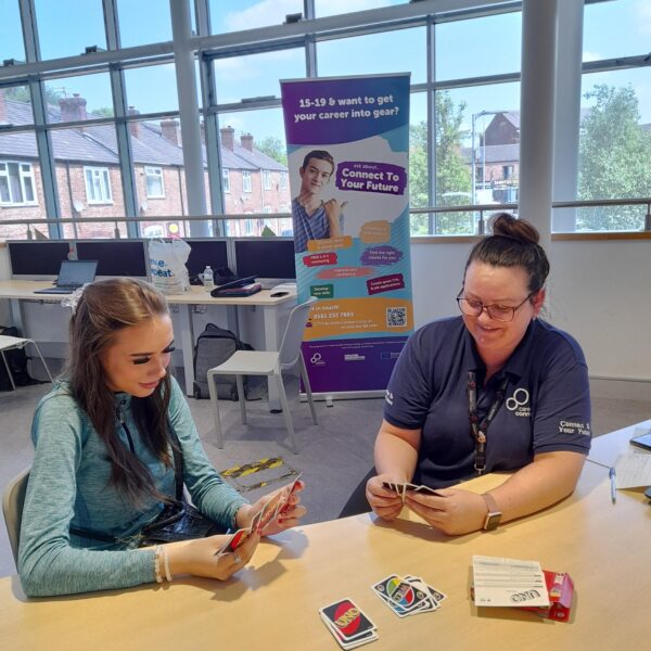 Inn this Connect to your Future wellbeing session, a young woman is playing a game of uno with a member of Career Connect staff.
