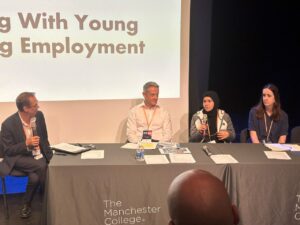 Youth ambassador Yasmina sat on a panel speaking into a microphone