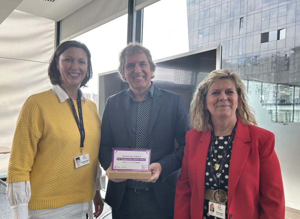 Career Connect CEO Sheila Clark (right) and Director of HR Danielle Kneale (left) receive the Liverpool City Region Fair Employment Charter Accredited Status Award from Metro Mayor Steve Rotherham (centre).