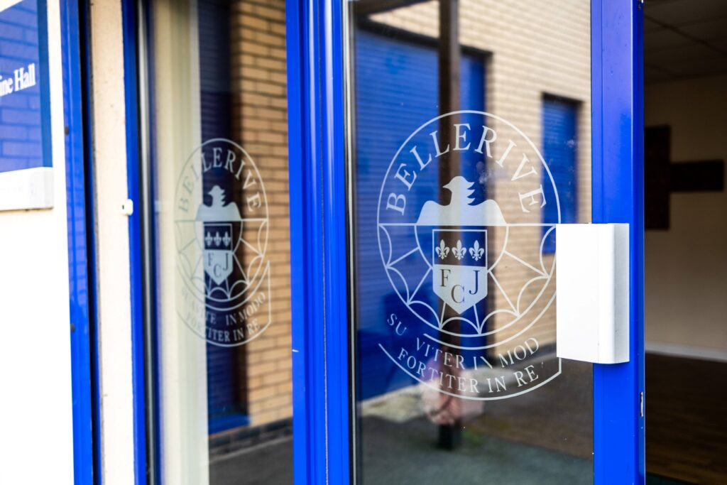 The entrance door to Bellerive school, with the school crest - an eagle and three stars - on the door.