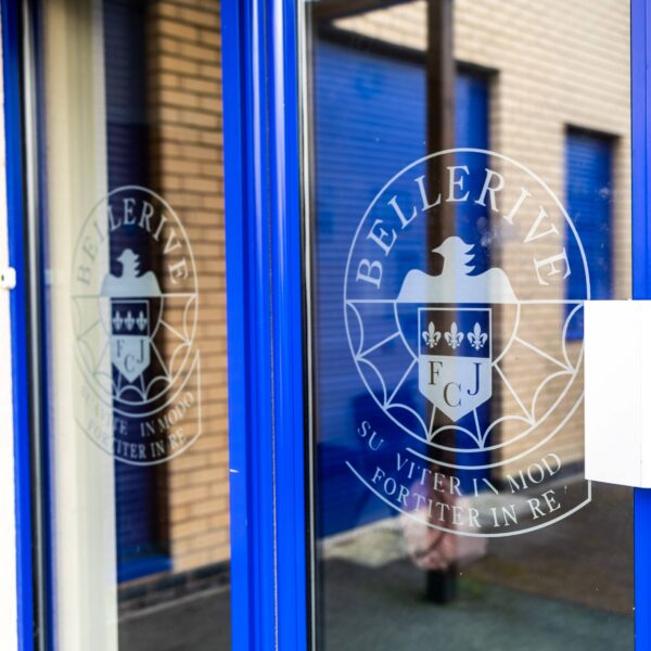 The entrance door to Bellerive school, with the school crest - an eagle and three stars - on the door.