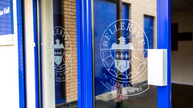 The entrance door to Bellerive school, with the school crest - an eagle and three stars - on the door.