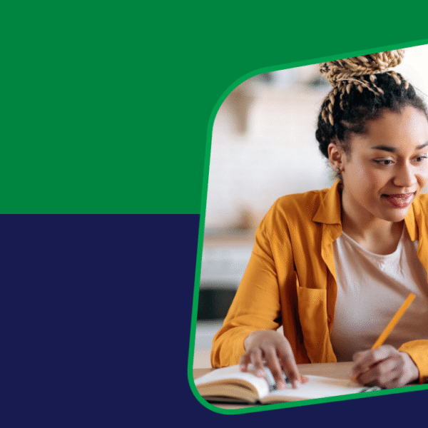 A woman with her hair in a bun is working at a laptop.