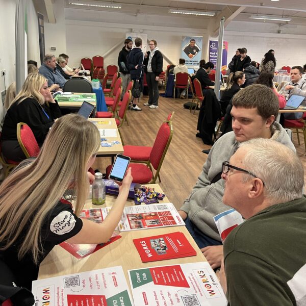 A young man and his father speaking to a careers adviser at Liverpool Careers Fair,