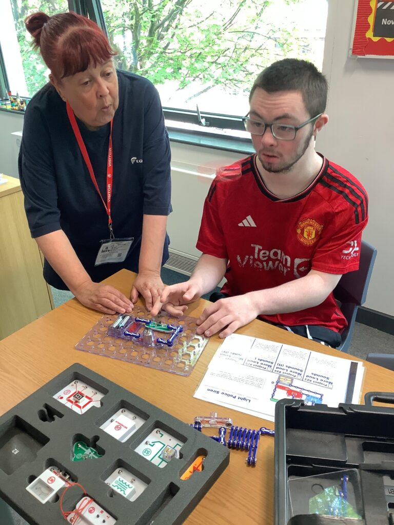 A teenage boy receiving advice and guidance during a training activity.