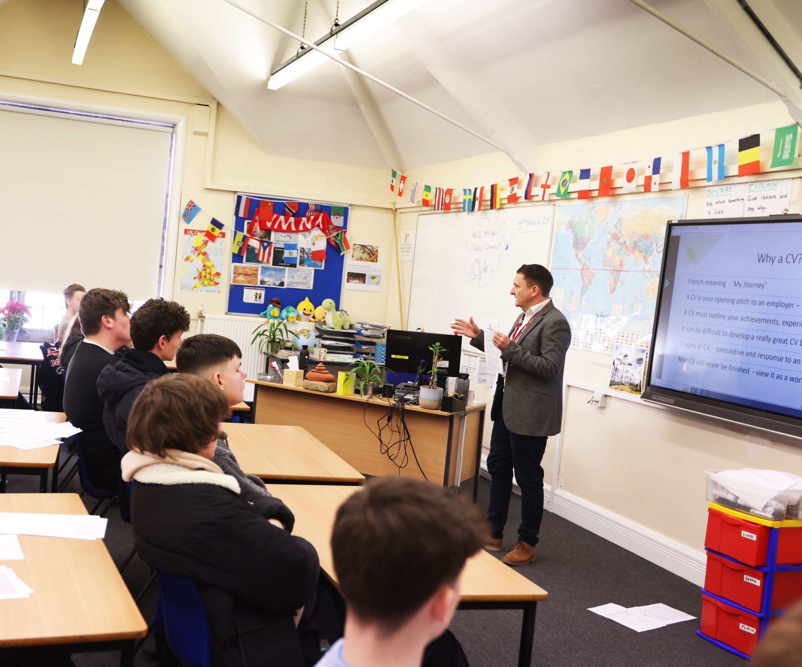 A male careers adviser giving a presentation on CVs to a classroom of students