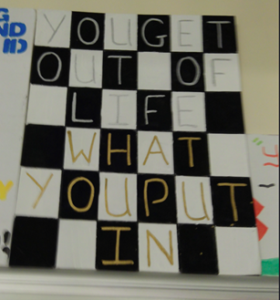 A chessboard design mural spelling out the message "you get out of life what you put in" in each of the squares.
