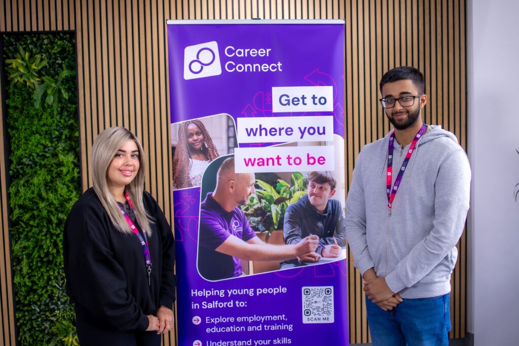 Career Connect Apprentices Olivia and Muzammil. They are standing each side of a Career Connect banner and smiling.