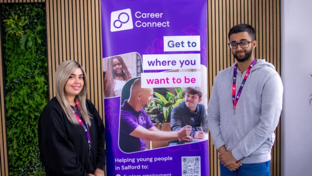 Career Connect Apprentices Olivia and Muzammil. They are standing each side of a Career Connect banner and smiling.