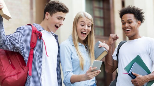 Three people receiving the exam results with smiles upon their faces.