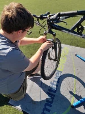 Image of young person mending a bike.