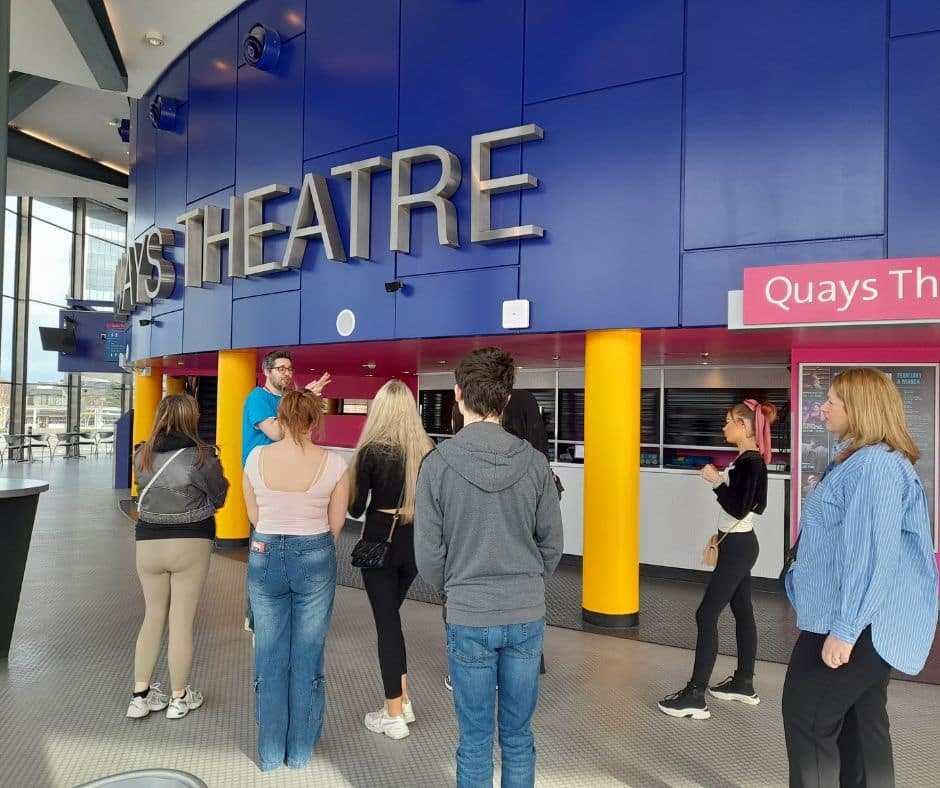 An image of a group of young people standing in the foyer of The Lowry, during their Discover Your Future tour.