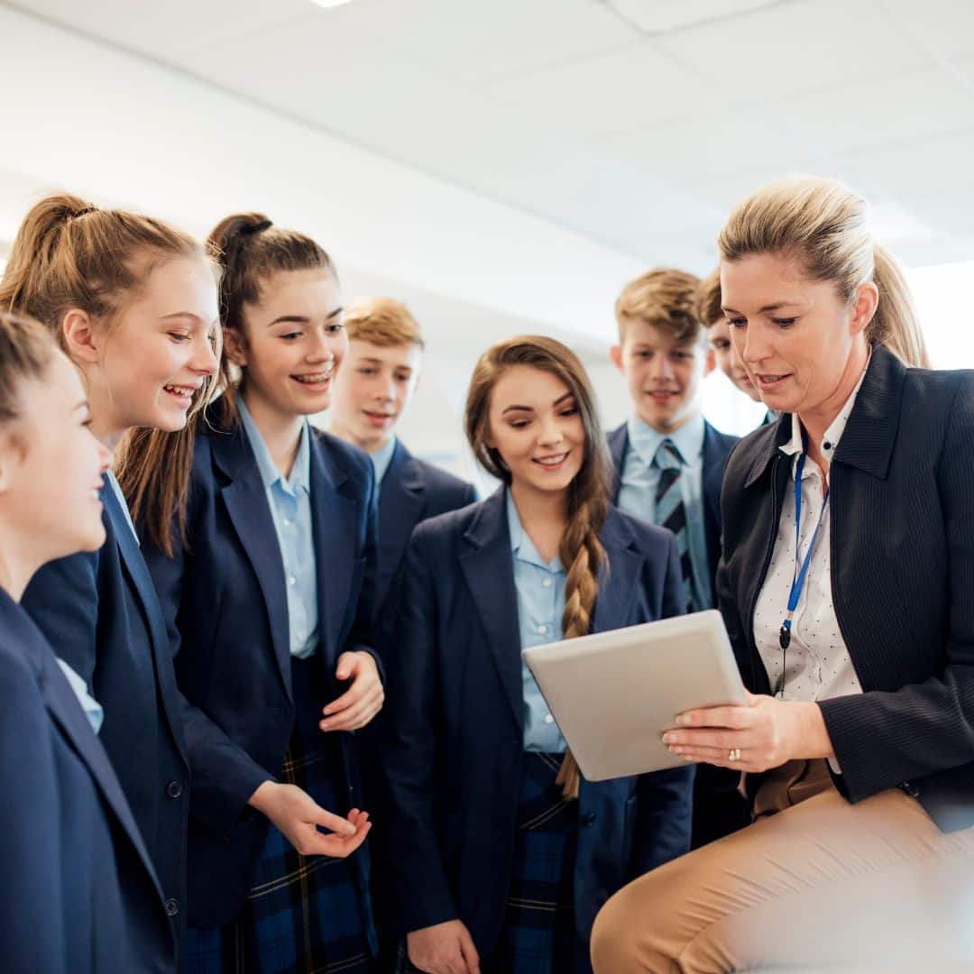 A group of school pupils talking to their teacher.