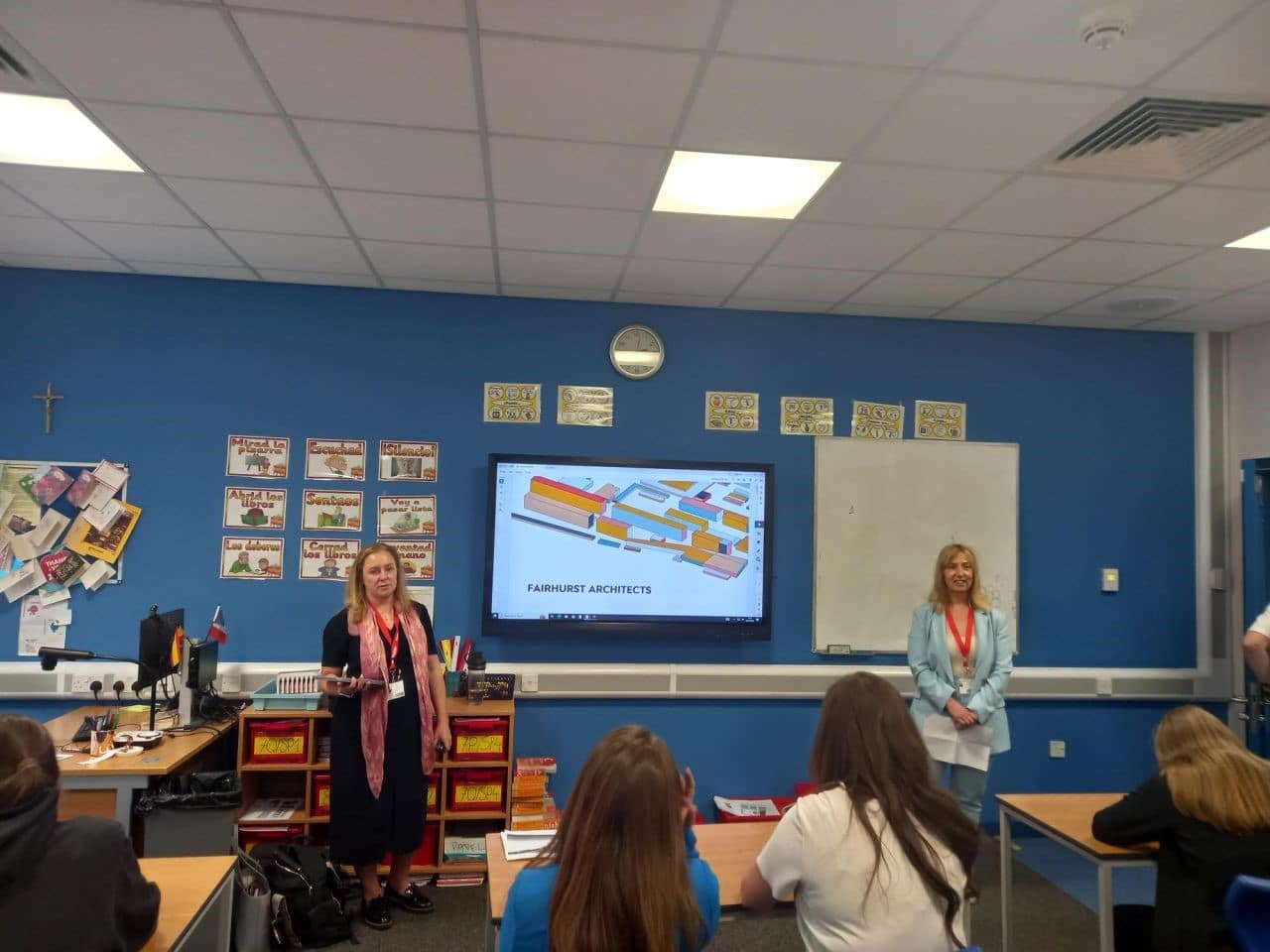 Two women are in a classroom presenting to a group of female students. A presentation behind them says 'Careers in Architecture'