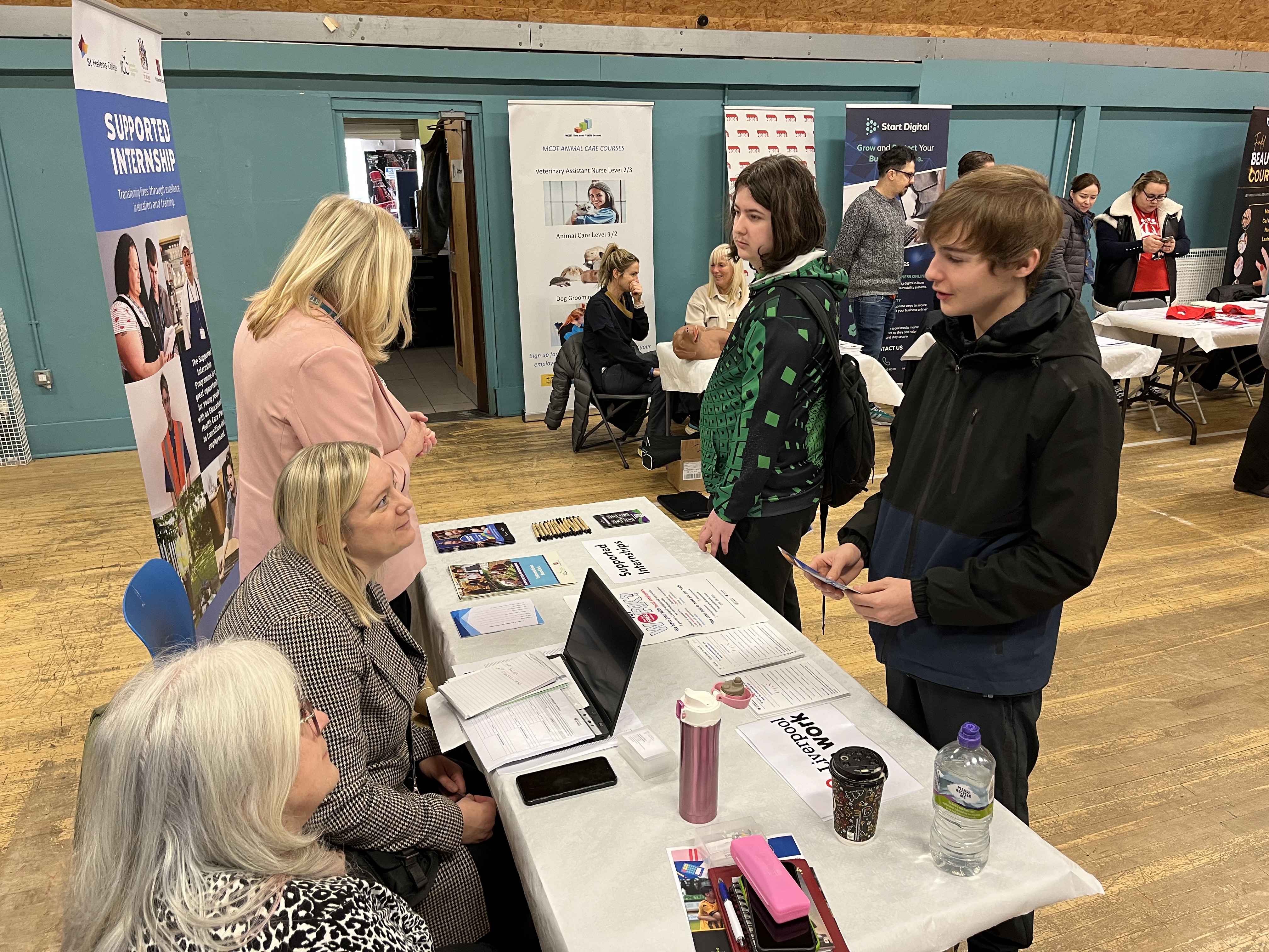 Young people receiving advice from a training provider at a careers event.